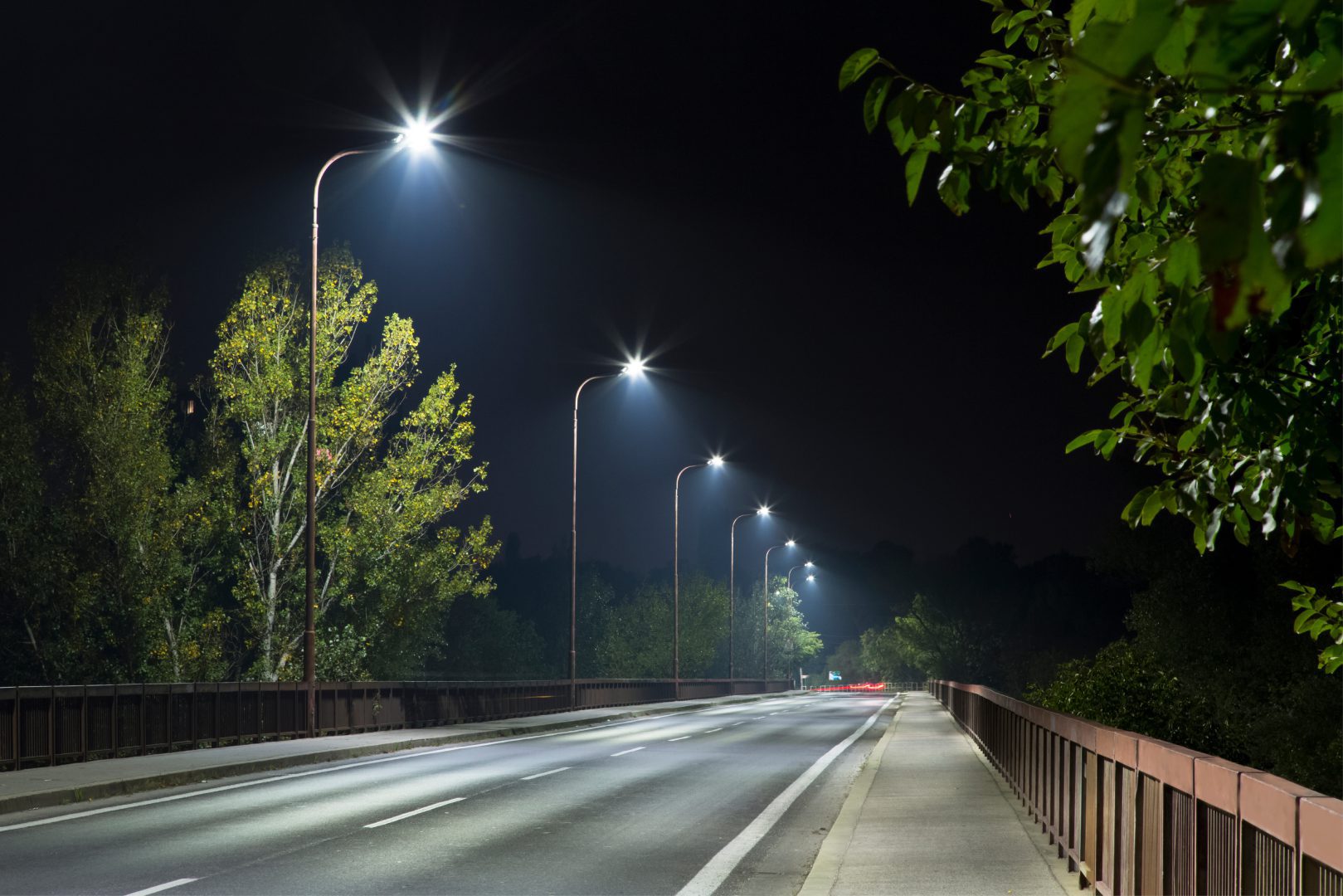 Dunkle Straße in der Nacht, beleuchtet von LED-Straßenlaternen